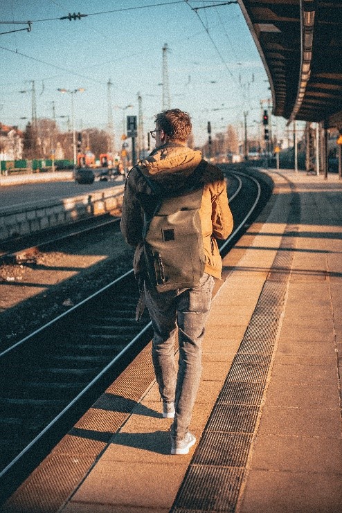 man walking along train platform